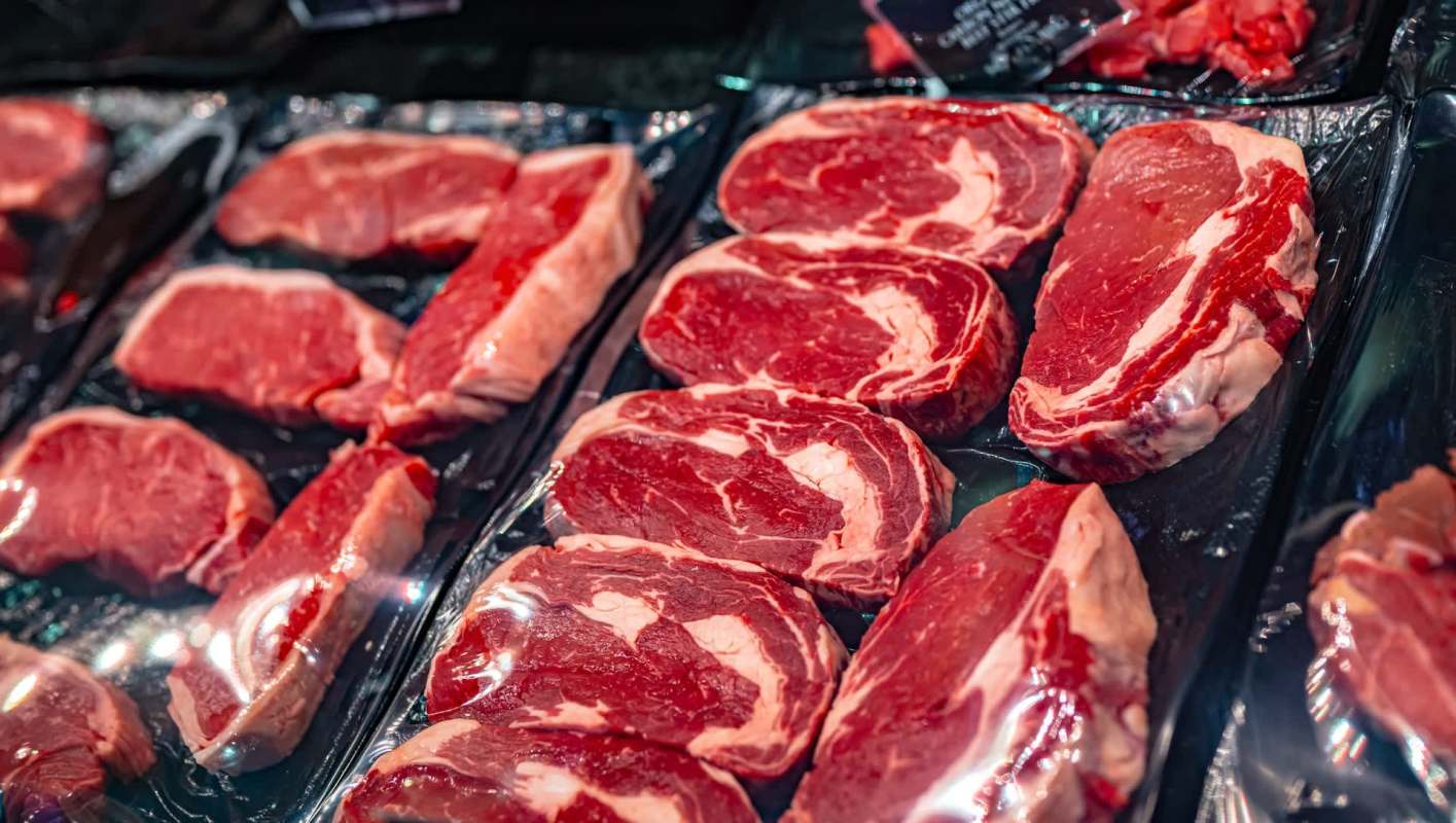 Various cuts of raw beef steaks displayed in plastic packaging.