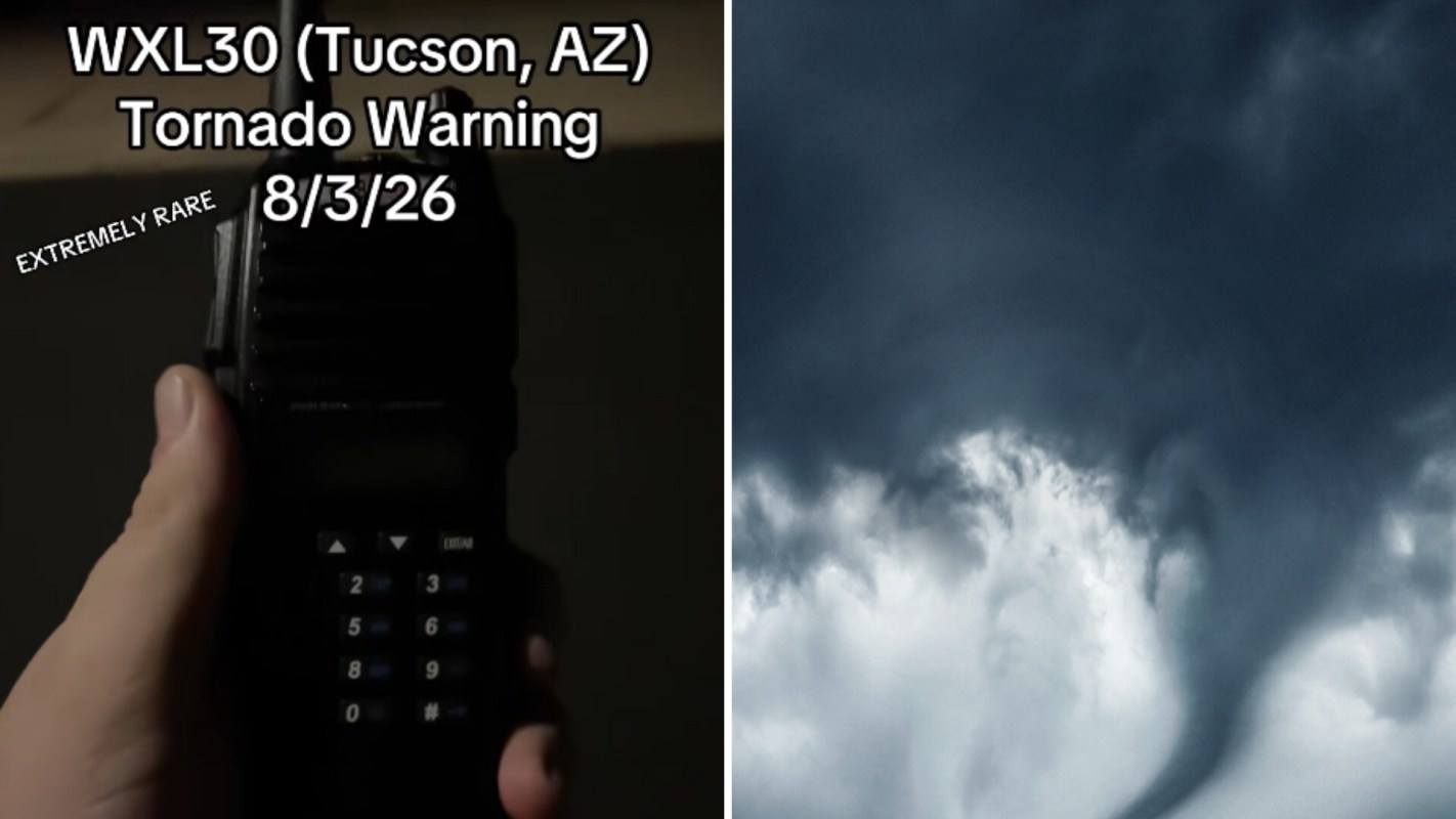 A hand holds a weather radio displaying a tornado warning over dark, swirling clouds.