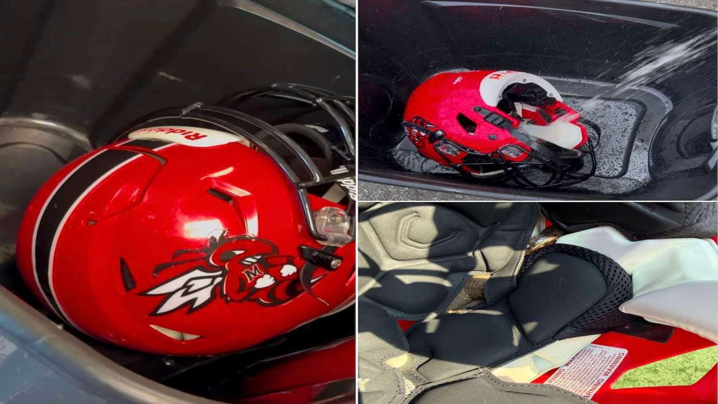 A red football helmet resting in a bin filled with water and soap and a snake