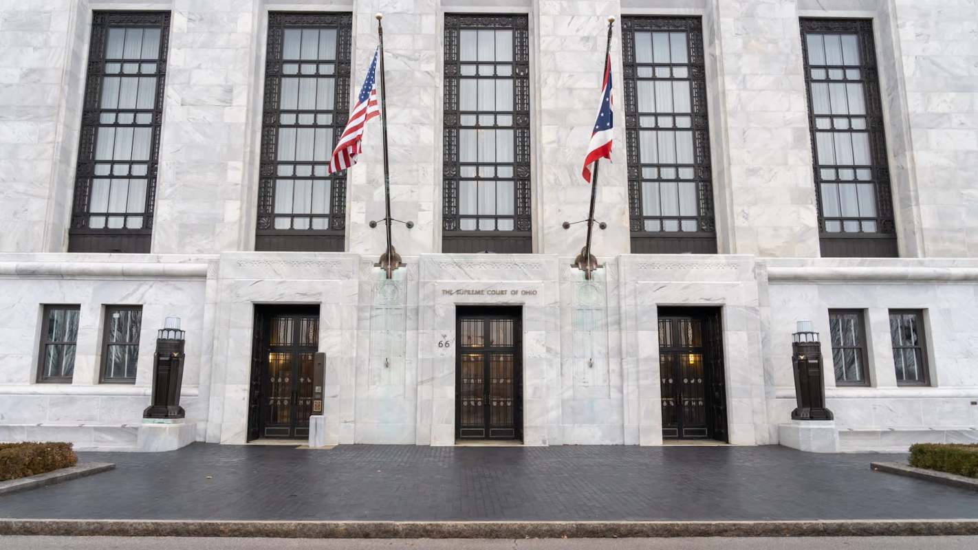 The entrance of the Supreme Court of Ohio, featuring three doors and American and Ohio flags.