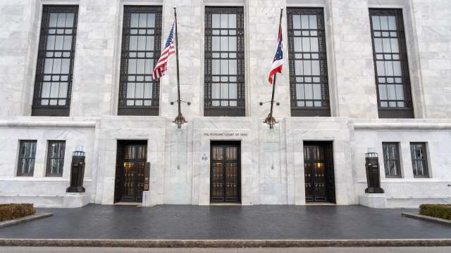 The entrance of the Supreme Court of Ohio, featuring three doors and American and Ohio flags.