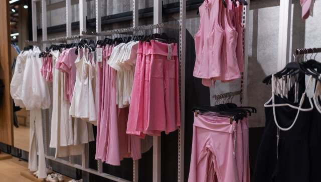 A display of clothing including various pink and white garments arranged on hangers in a retail setting.