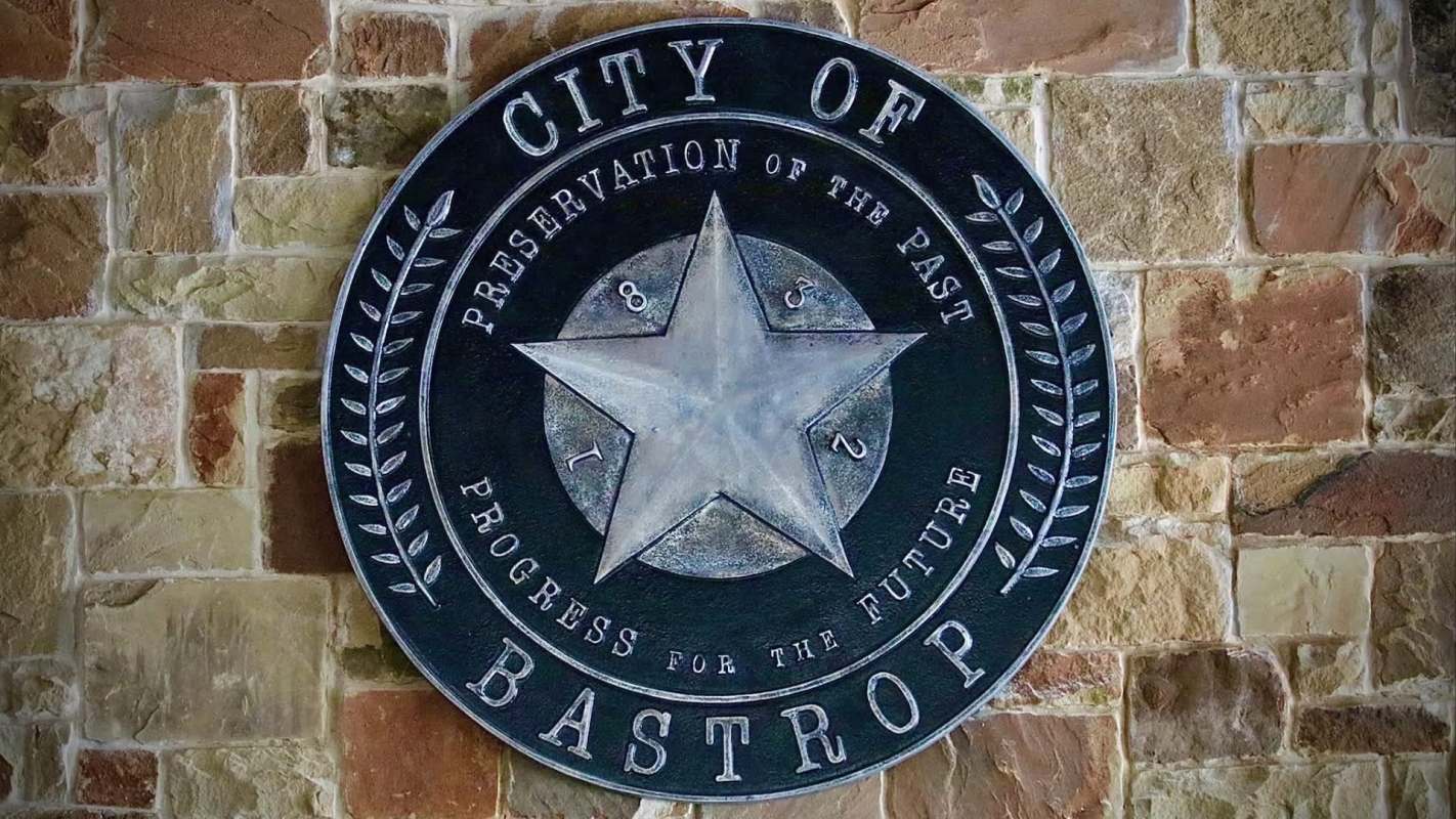 The seal of Bastrop, Texas, on a stone wall.