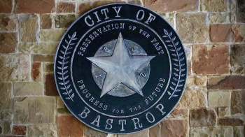 The seal of Bastrop, Texas, on a stone wall.