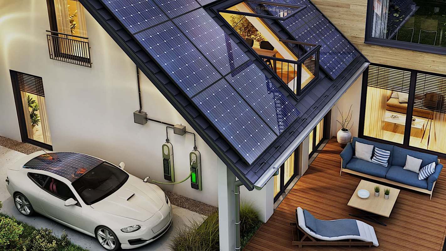 A modern house with solar panels on the roof and an electric vehicle charging station in the driveway.