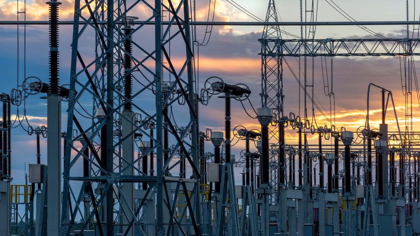 Electric transmission structures and equipment against a sunset sky.