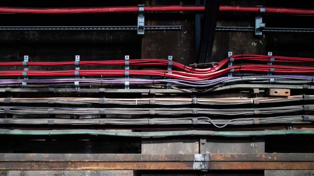 A collection of various colored electrical cables and wires mounted against a dark background.