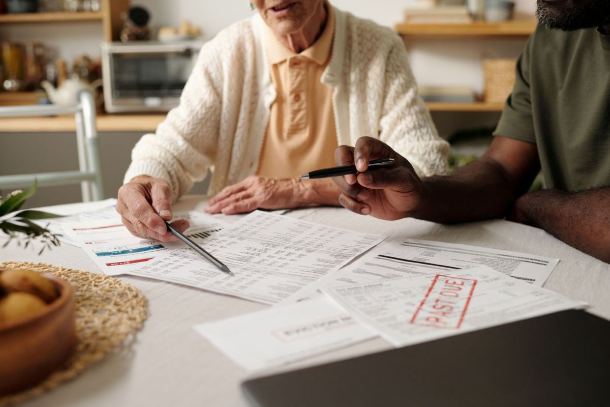 A woman and a man review financial documents on a table.