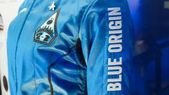 A blue flight suit with a "Blue Origin" logo and patch displaying the number 21.