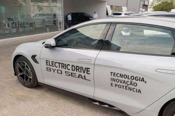A white electric car with "Electric Drive BYD Seal" and additional text displayed on the side.