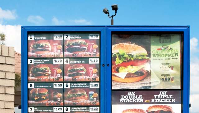A Burger King drive-thru menu board displaying various burger options and prices.