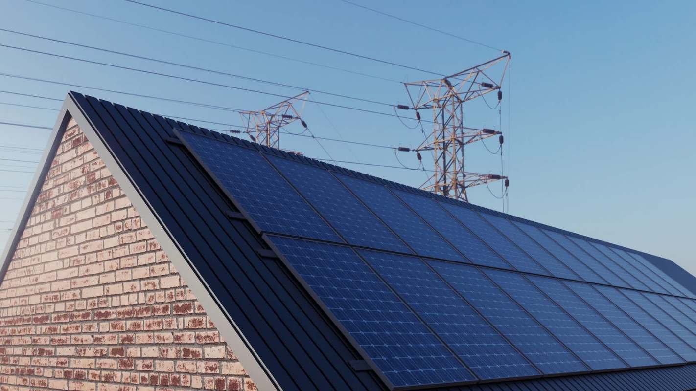 A roof with solar panels and power lines in the background under a clear blue sky.
