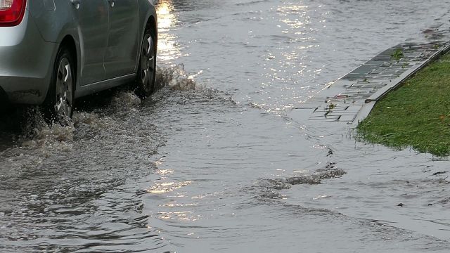 A car driving on a flooded street.