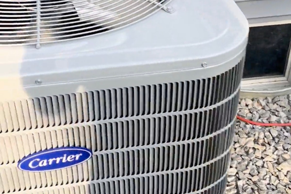 An outdoor air conditioning unit with a blue Carrier logo.