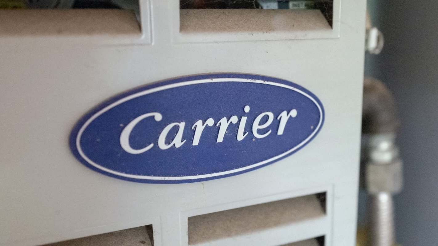 A blue and white label displaying the word "Carrier" on a HVAC unit.