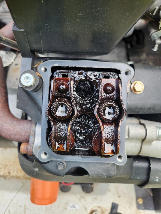 A generator spark plug covered in brown sludge.