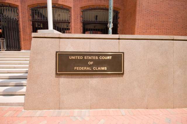 A sign for the United States Court of Federal Claims on a building facade.