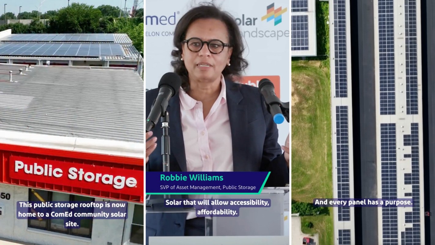 A woman speaks at a podium with solar panels visible on a nearby rooftop and in the background.