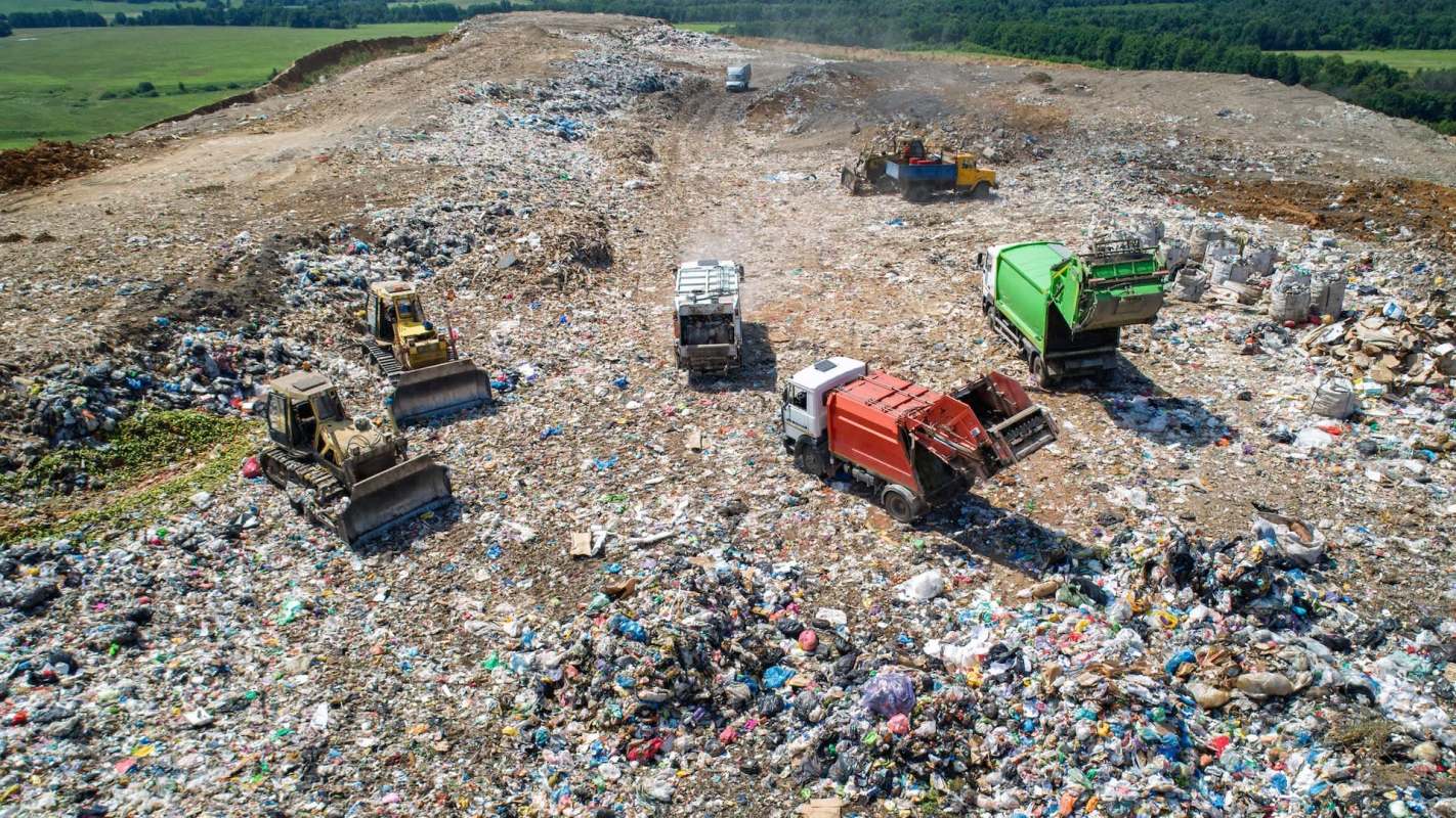 landfill operations with dump trucks and bulldozers pushing waste