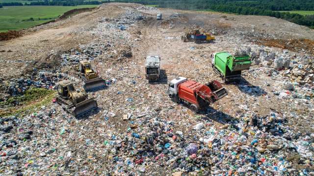landfill operations with dump trucks and bulldozers pushing waste