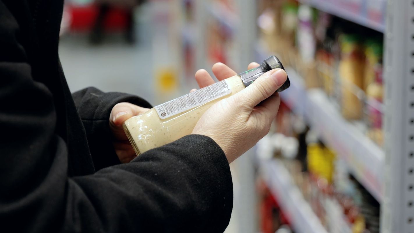 A shopper looking at a condiment's ingredient label.