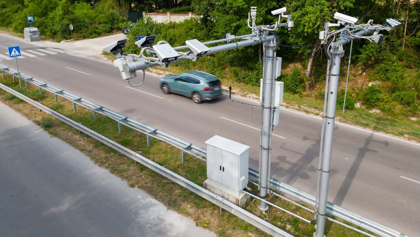 Traffic surveillance cameras on metal poles.