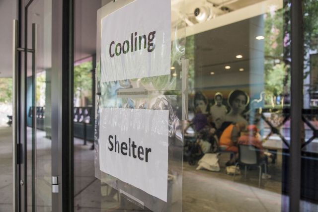Signs for a "cooling shelter" on a door.