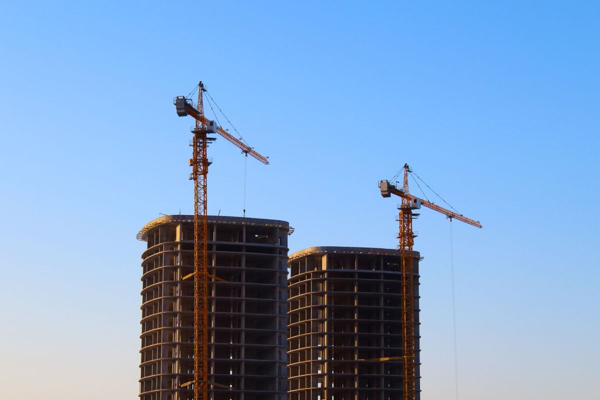 Cranes at a construction site with two towers.