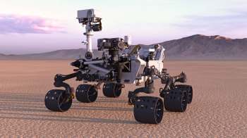 A robotic rover on a desert landscape with mountains in the background.