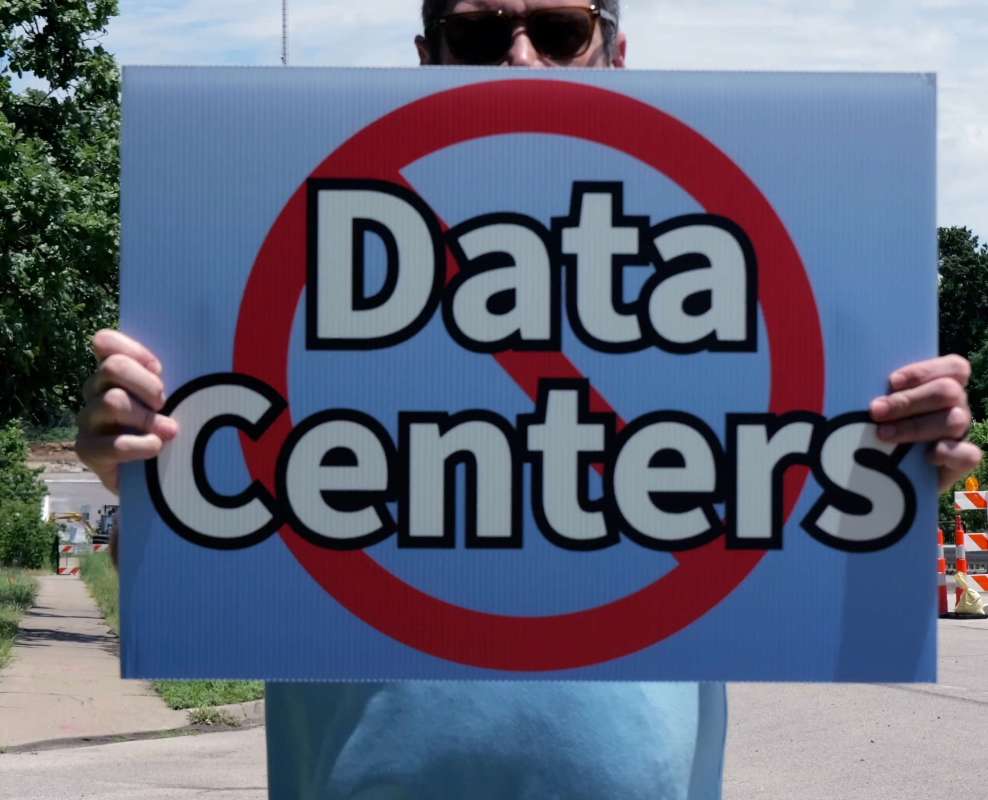 A person holds a sign that reads "No Data Centers."