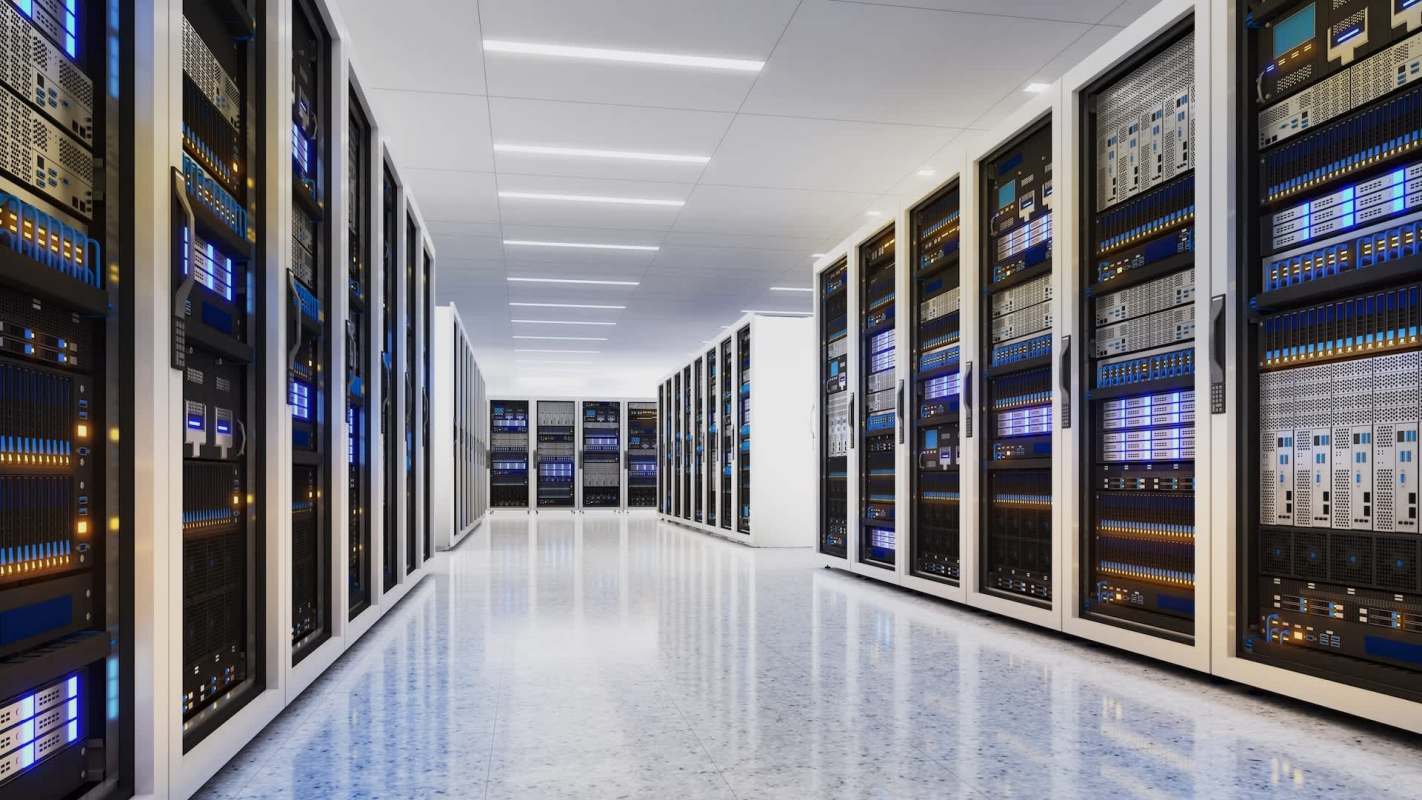 A data center with multiple server racks and bright blue lighting.