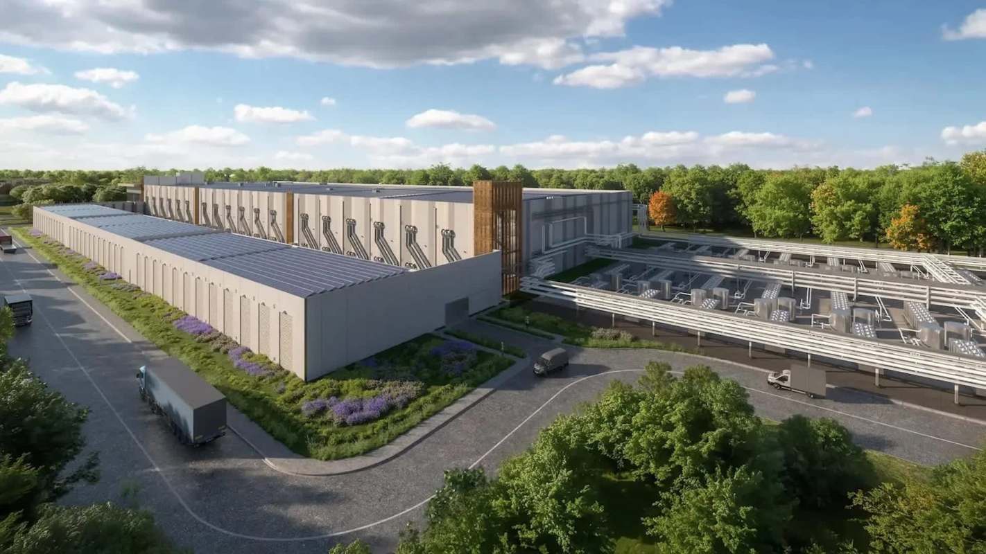 A modern industrial building with solar panels and trucks parked outside, surrounded by trees and landscaping.