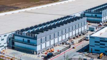A data center complex with multiple exterior cooling units and construction equipment.