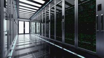 A data center corridor with server racks and digital displays along the walls.