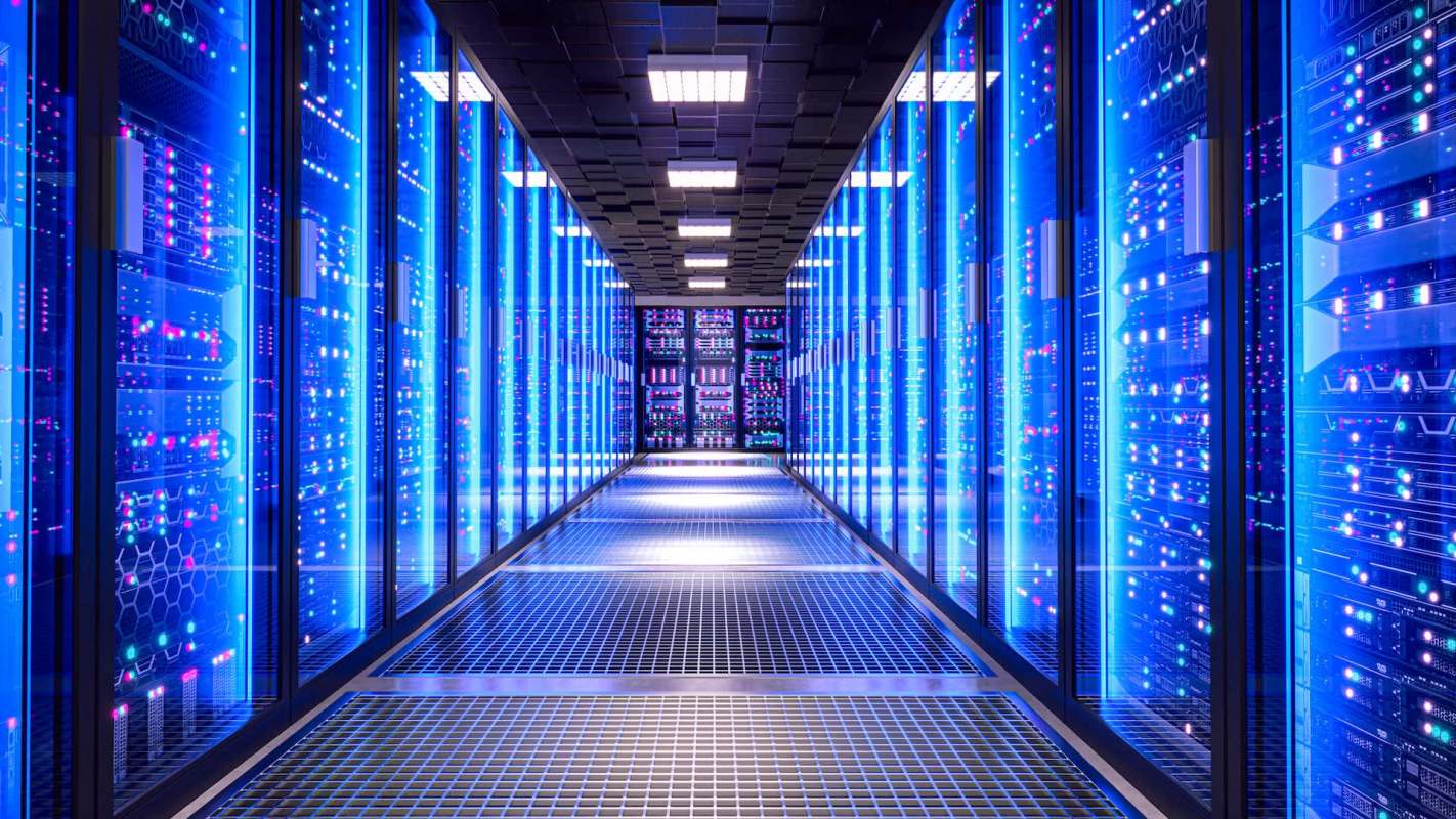 A corridor lined with illuminated server racks in a data center.