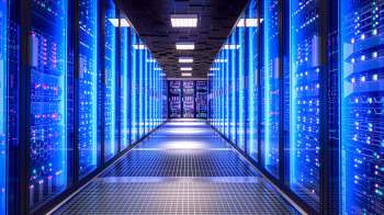 A corridor lined with illuminated server racks in a data center.