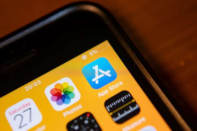 A smartphone screen displaying app icons, including the App Store and Photos.