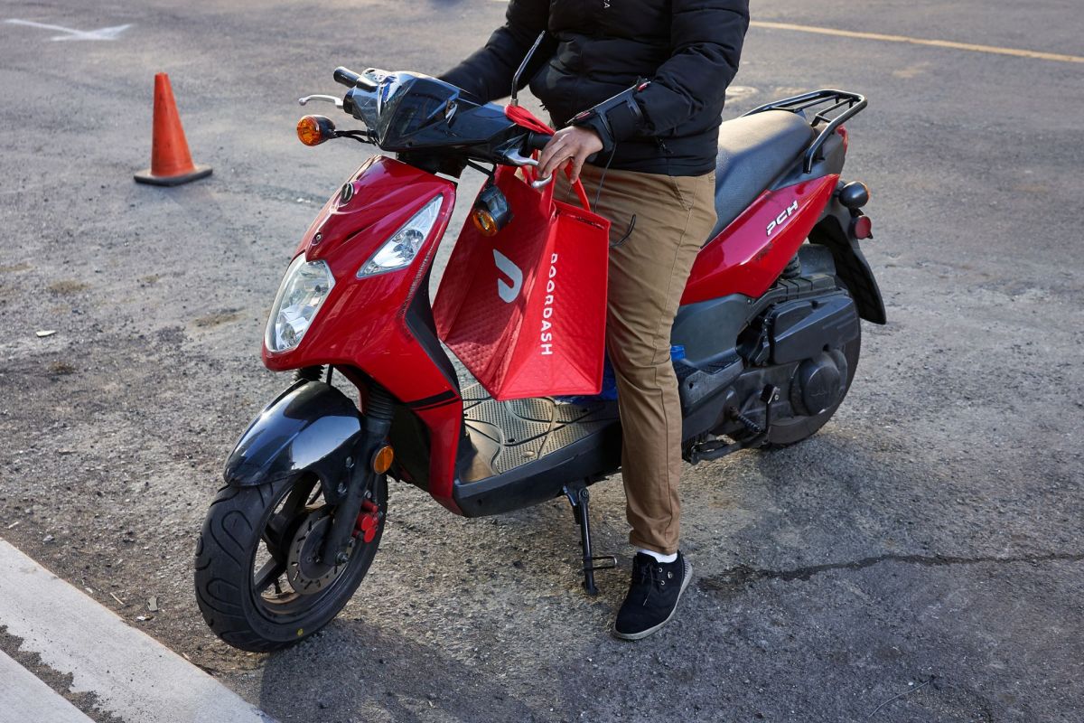 A DoorDash delivery worker on a motorbike.