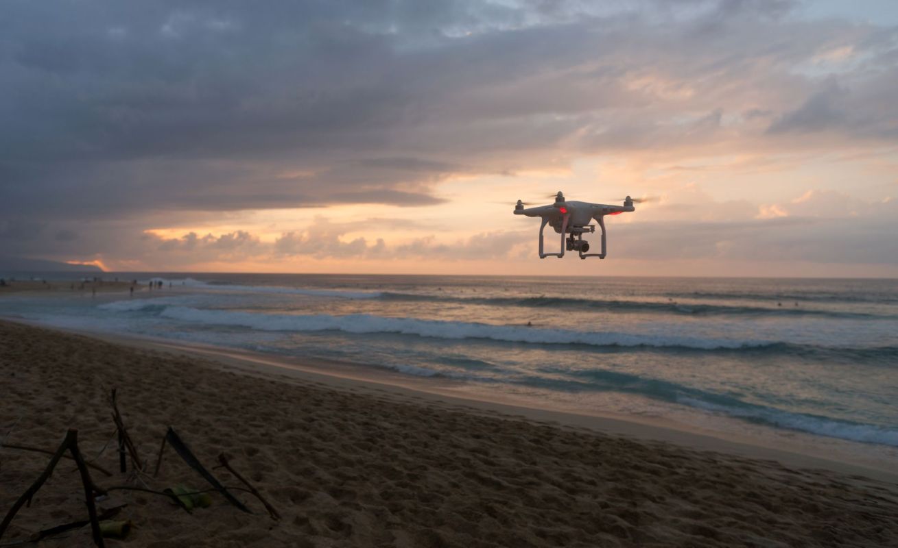A drone flying over a beach.