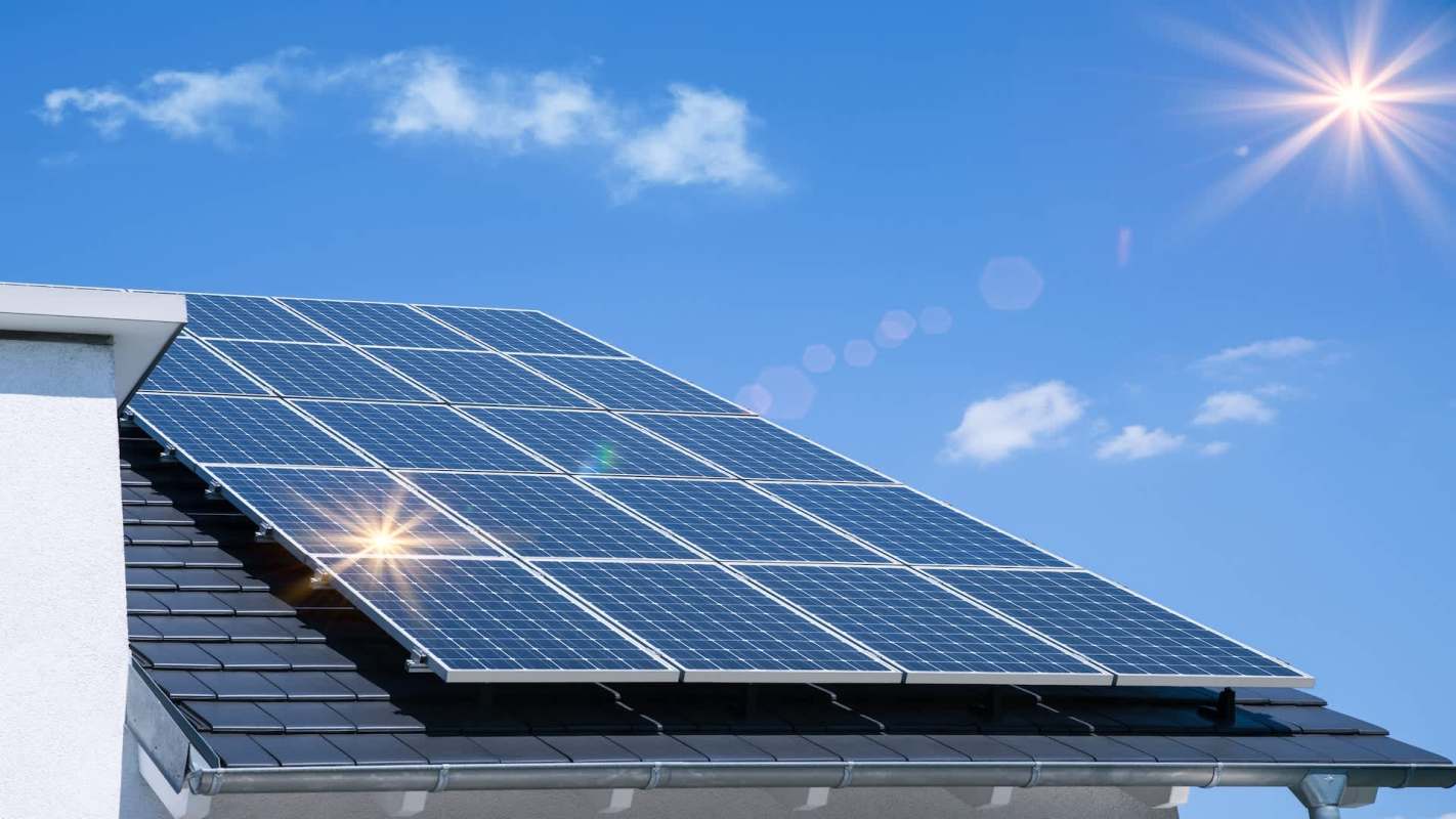 A roof with solar panels under a clear blue sky.