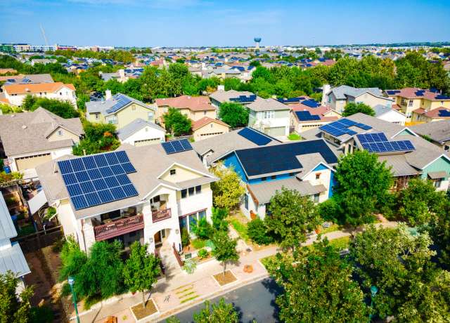 Houses with solar panels in a suburban neighborhood.