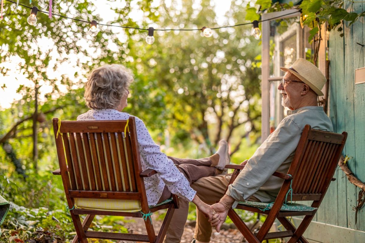 An elderly couple sitting outside.