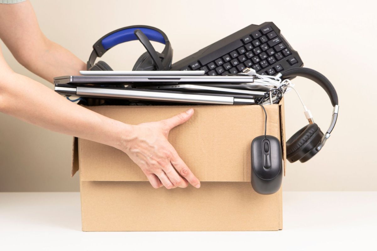 A person holding a box of electronics.