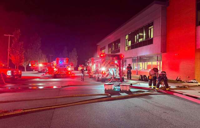 Firefighters and fire trucks at a school.