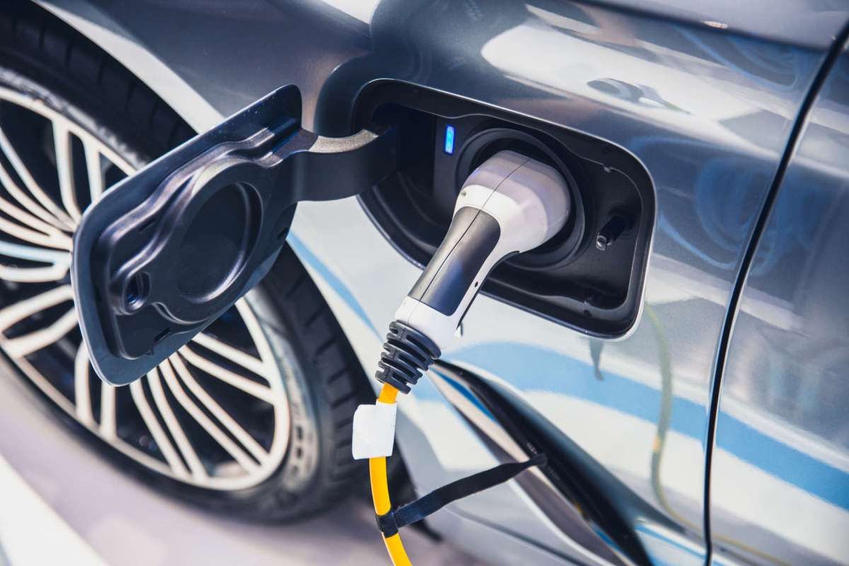 An electric vehicle charging with a plugged charger in the charging port.