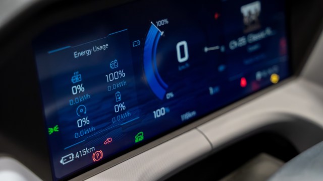 A digital display showing energy usage, battery status, and vehicle range in a car.