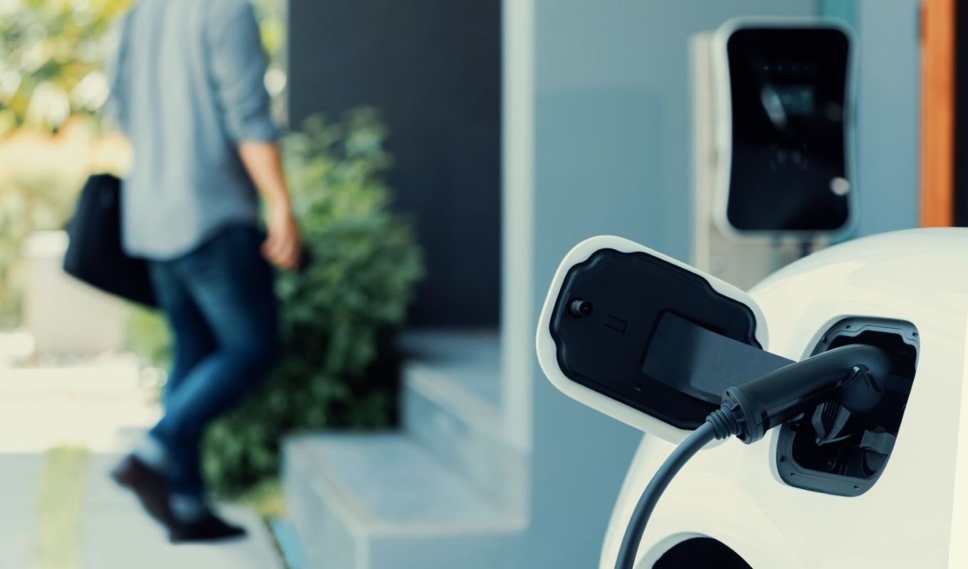 A person charging an EV at their home.