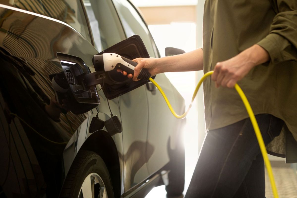 A person plugging a charger into their EV.