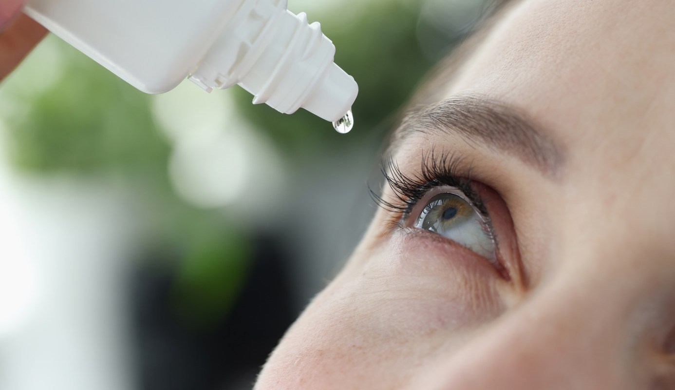 A person applying eye drops.