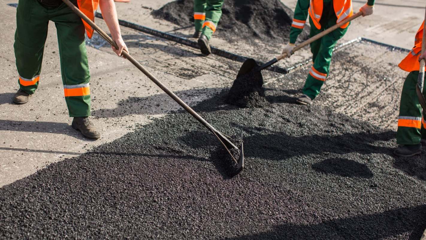 Workers laying asphalt.